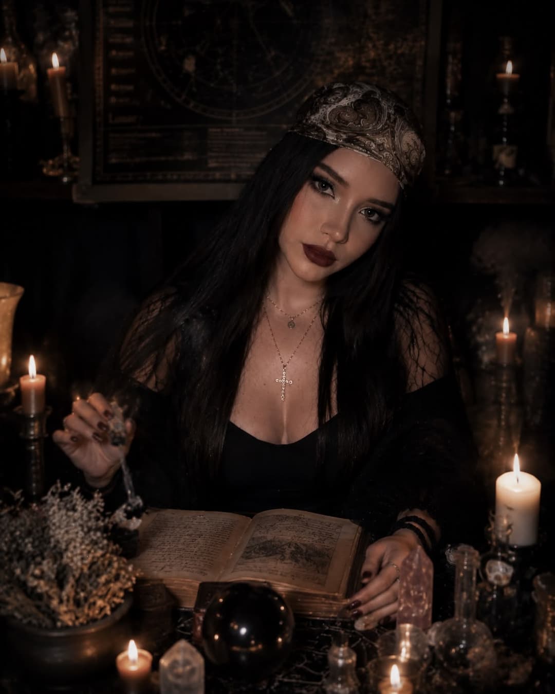 Circe mostrando la carta de La Luna entre velas